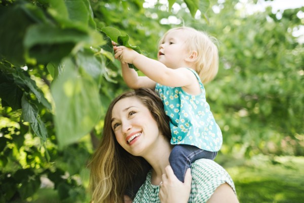 Mother carrying daughter (12-17 months) on shoulders