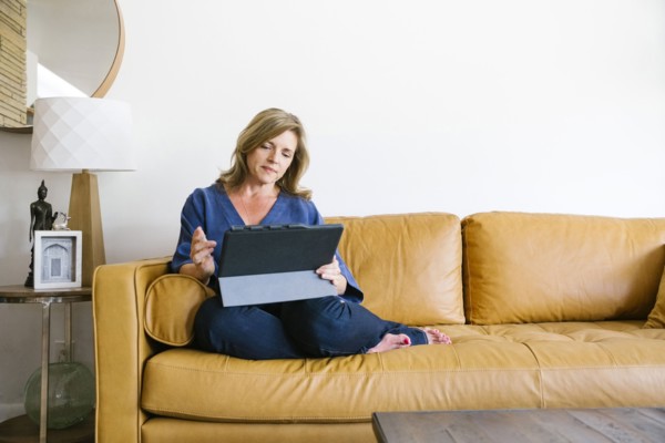 Woman using digital tablet on sofa