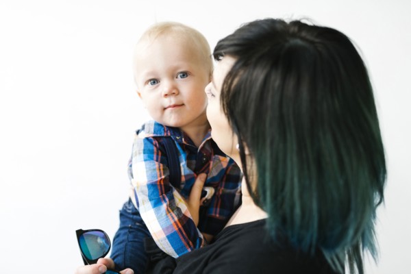 Portrait of mother holding son (12-17 months) against white background
