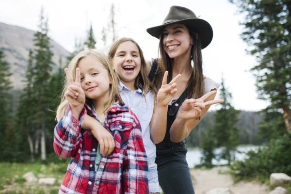 Outdoor portrait of mother with kids (6-7, 8-9) in forest