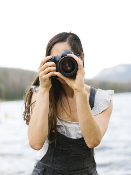 Woman taking pictures by lake