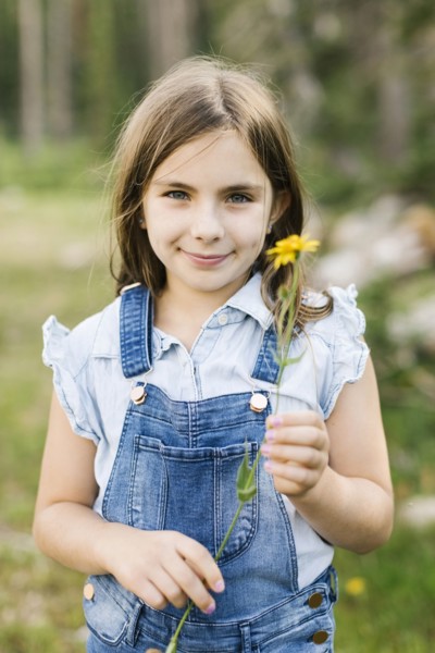 Portrait of girl (8-9) holding wildflowers