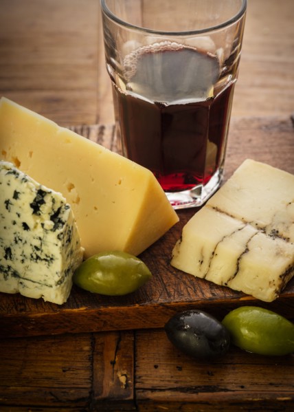 Assorted cheeses with olives and red wine
