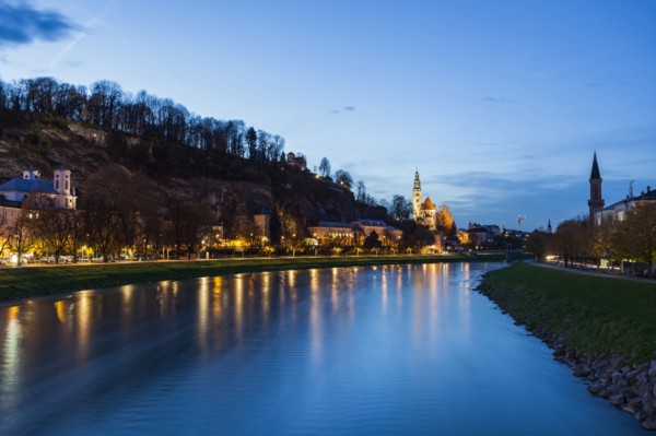 Austria, Salzburg, River and illuminated riverbank at dusk