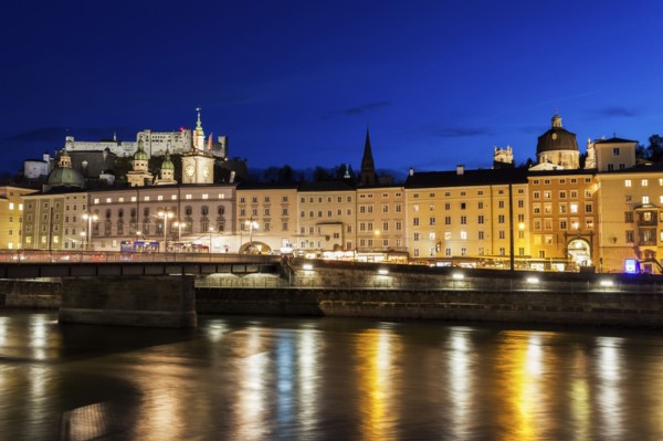 Austria, Salzburg, Riverbank with buildings at night