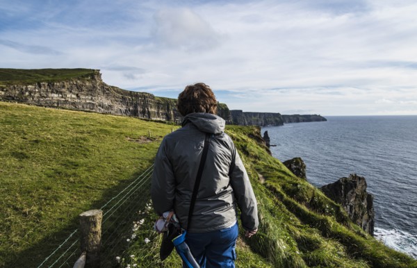 Ireland, County Clare, Woman walking along Cliffs of Moher