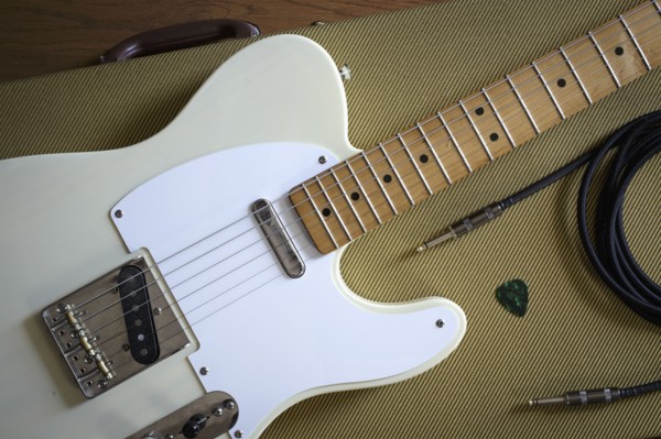 Fender Telecaster and music equipment lying on guitar case