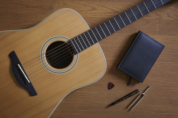 Acoustic guitar and tuning fork lying on floor