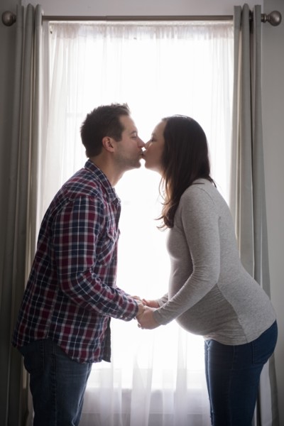 Mid adult couple kissing in front of window