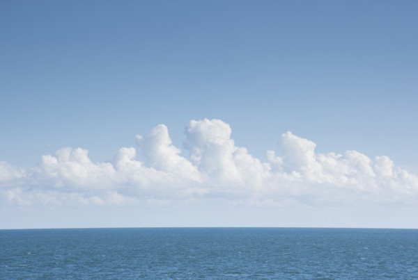 White cumulus clouds above blue Atlantic Ocean