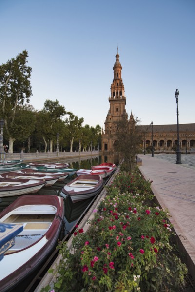 Spain, Andalusia, Seville, Rowboats moored in canal on Plaza de Espana at dawn