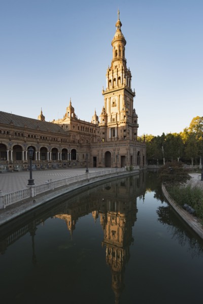 Spain, Andalusia, Seville, Tower in Plaza de Espana reflected in water