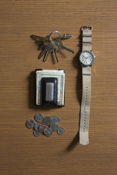 Watch, keys and money on table