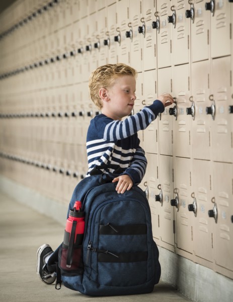 Boy with backpack by school lockers