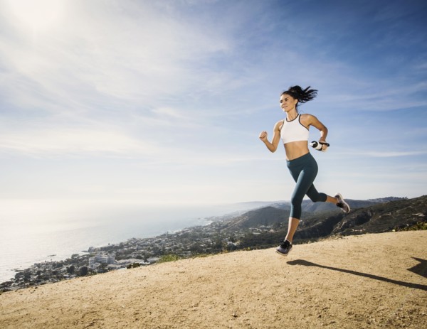 Woman jogging on mountain with water bottle