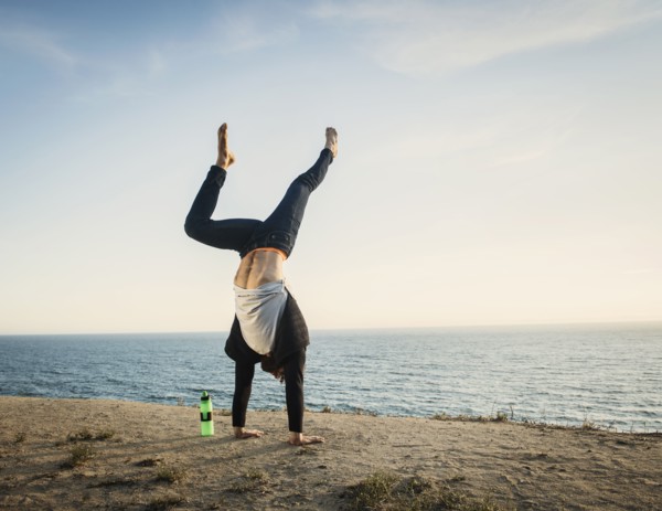 Man doing handstand on beach