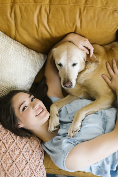 Woman lying on sofa with dog