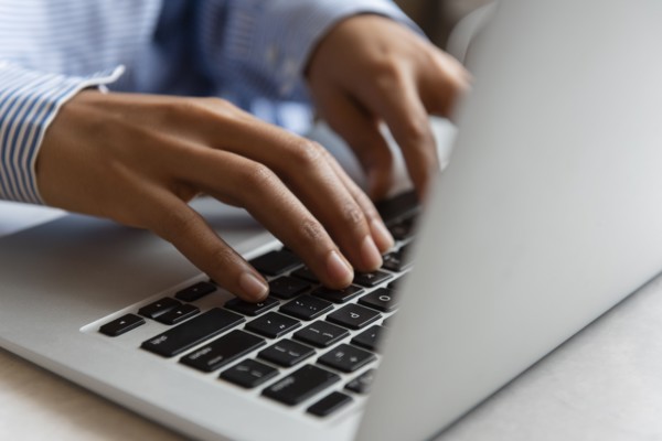 Hands of woman typing on laptop