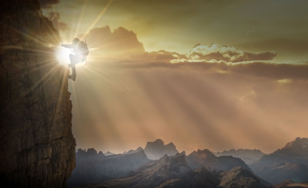 Silhouette of woman rock climbing in the Dolomites at sunrise