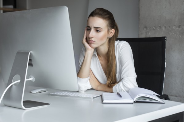 Depressed businesswoman working at desktop computer