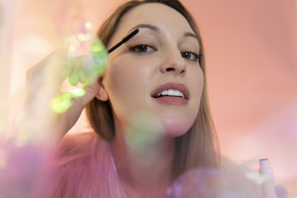 Young woman applying mascara