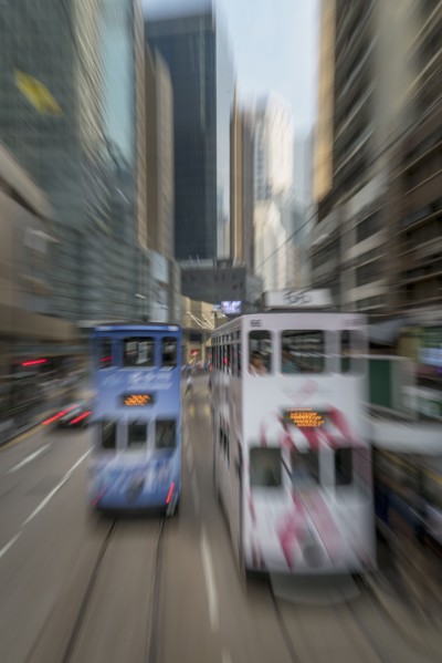 Blurred image of double-decker trams on street in Hong Kong, China