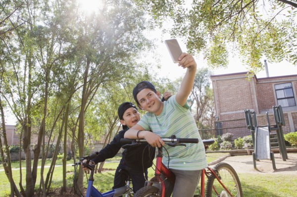 Brothers taking selfie on bicycles