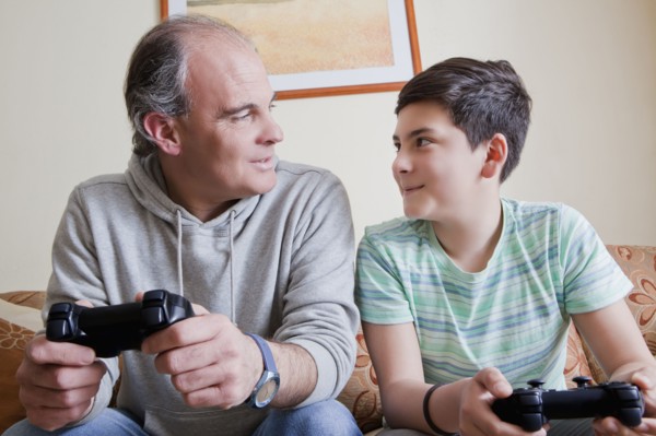 Father and teenage son playing video game
