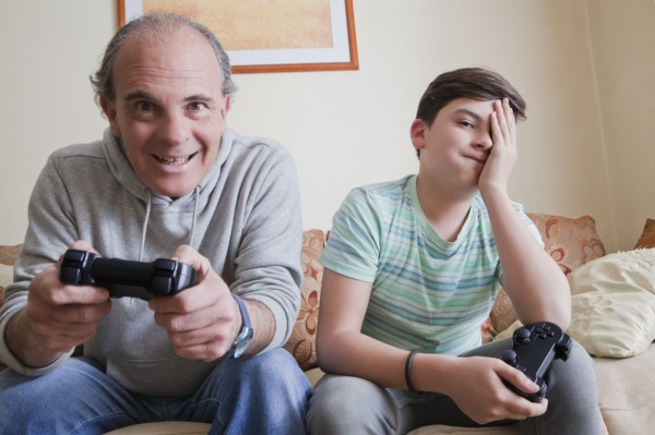 Father and teenage son playing video game