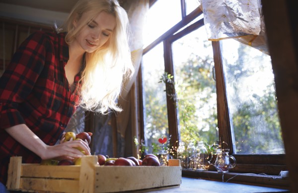 Woman with crate of apples by window