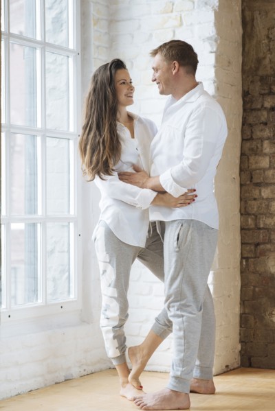 Smiling couple embracing by window