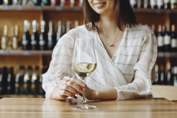 Woman holding glass of white wine