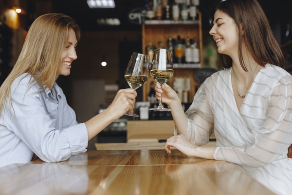 Young women toasting with glasses of white wine
