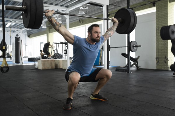 Mid adult man weight lifting in gym
