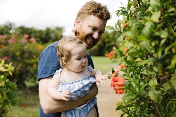 Man showing baby daughter flowers