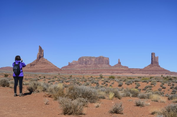 Woman wearing backpack by buttes in Monument Valley, Arizona, USA