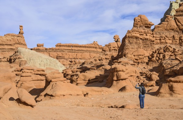 Woman photographing hoodoos in Goblin Valley State Park, Utah, USA