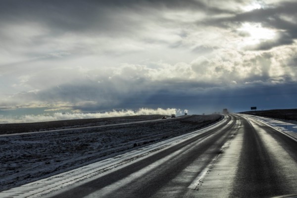 Country road with snow under overcast sky