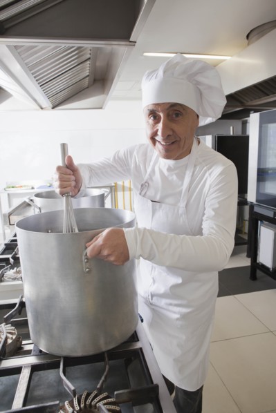 Chef using whisk in pot