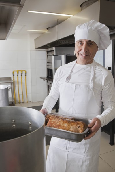 Chef holding meat in roasting tray