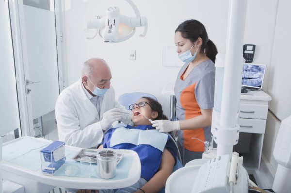 Teenage girl getting dental cleaning