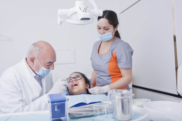 Teenage girl getting dental cleaning