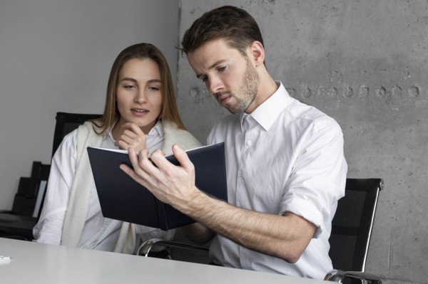 Businessman showing notebook to colleague