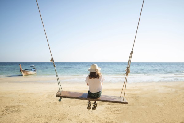 Young woman on swing at beach