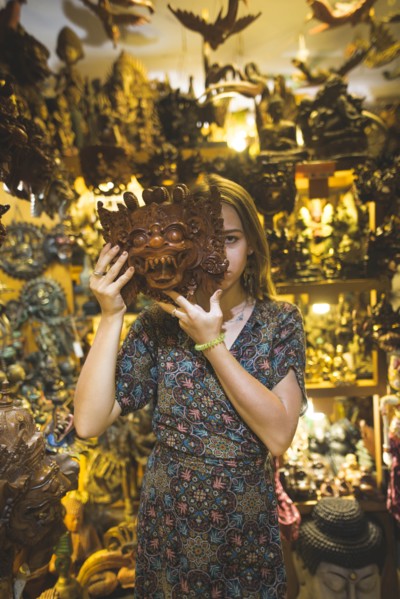 Young woman holding Barong mask in store in Bali, Indonesia