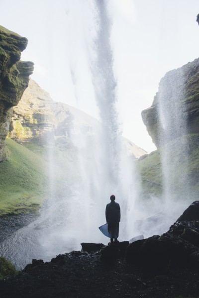 Silhouette of man behind Kvernufoss waterfall in Iceland