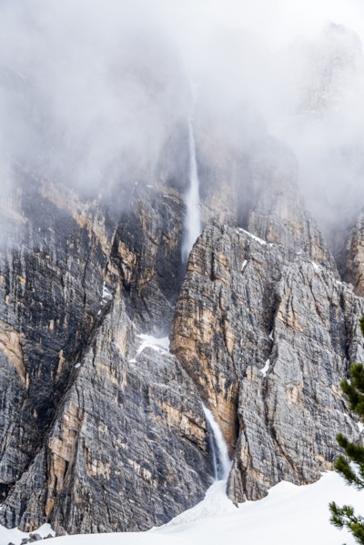 Snow falling down cliff in Dolomites, Italy