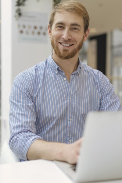 Smiling man using laptop