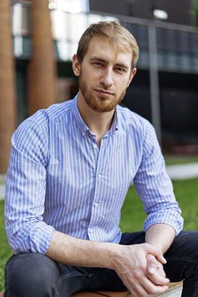 Man wearing striped shirt sitting on bench