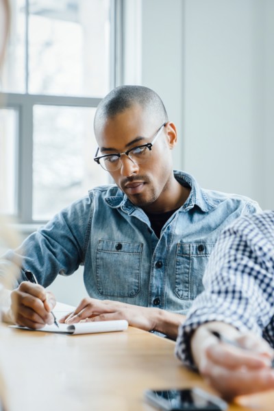 Man using note pad during meeting
